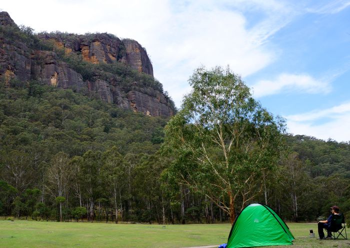 Man enjoying the view with his tent pitched at Newnes Campground, Wollemi National Park 